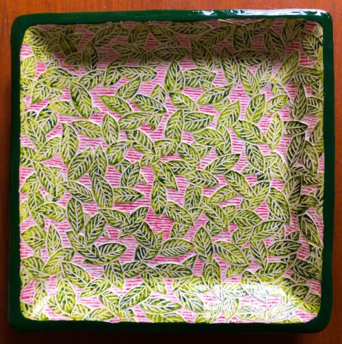 Square Salad Plate with Green Carved Leaves on a Pink Background